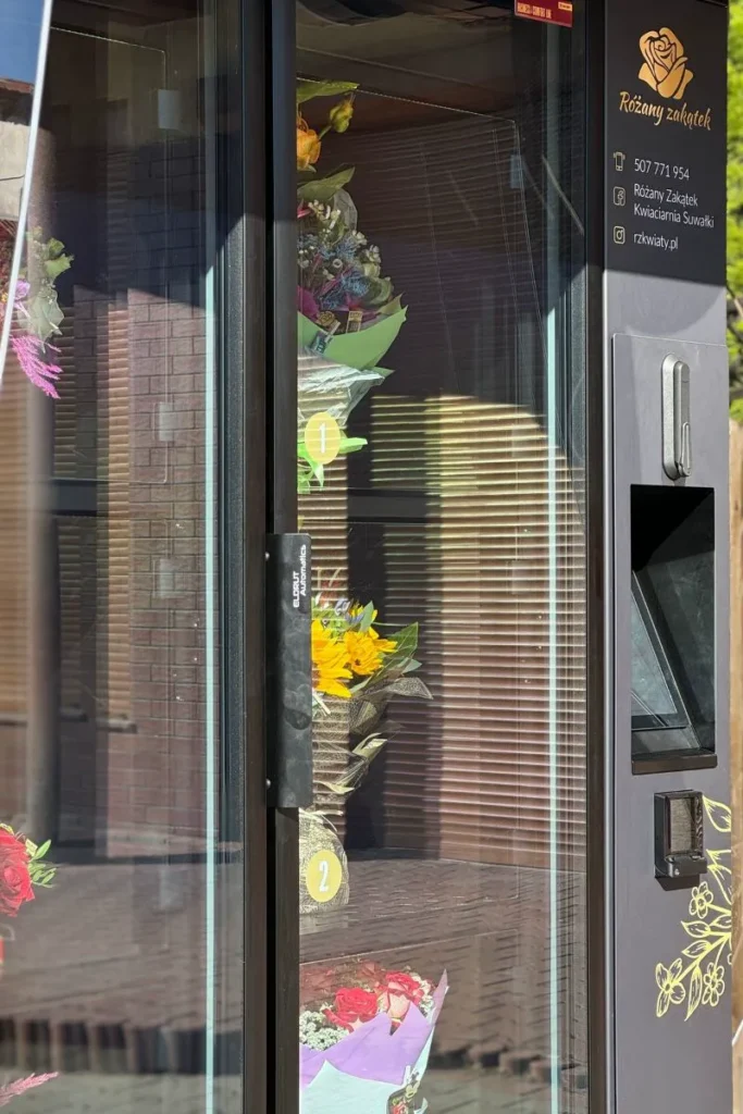 Kwiatomaty to również billboard reklamowy — elegancka, podświetlana konstrukcja, która przypomina przechodniom o lokalnej kwiaciarni i buduje jej rozpoznawalność. 