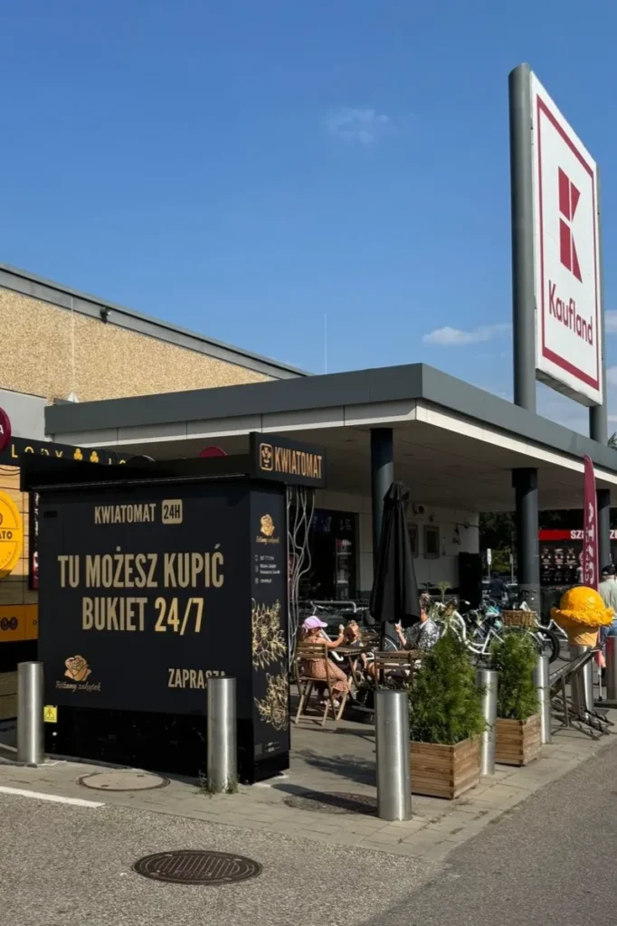 Kwiatomaty to również billboard reklamowy — elegancka, podświetlana konstrukcja, która przypomina przechodniom o lokalnej kwiaciarni i buduje jej rozpoznawalność. 