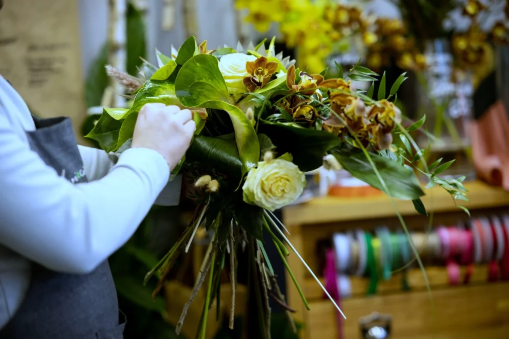 Florist preparing a hand-tied bouquet in a traditional flower shop