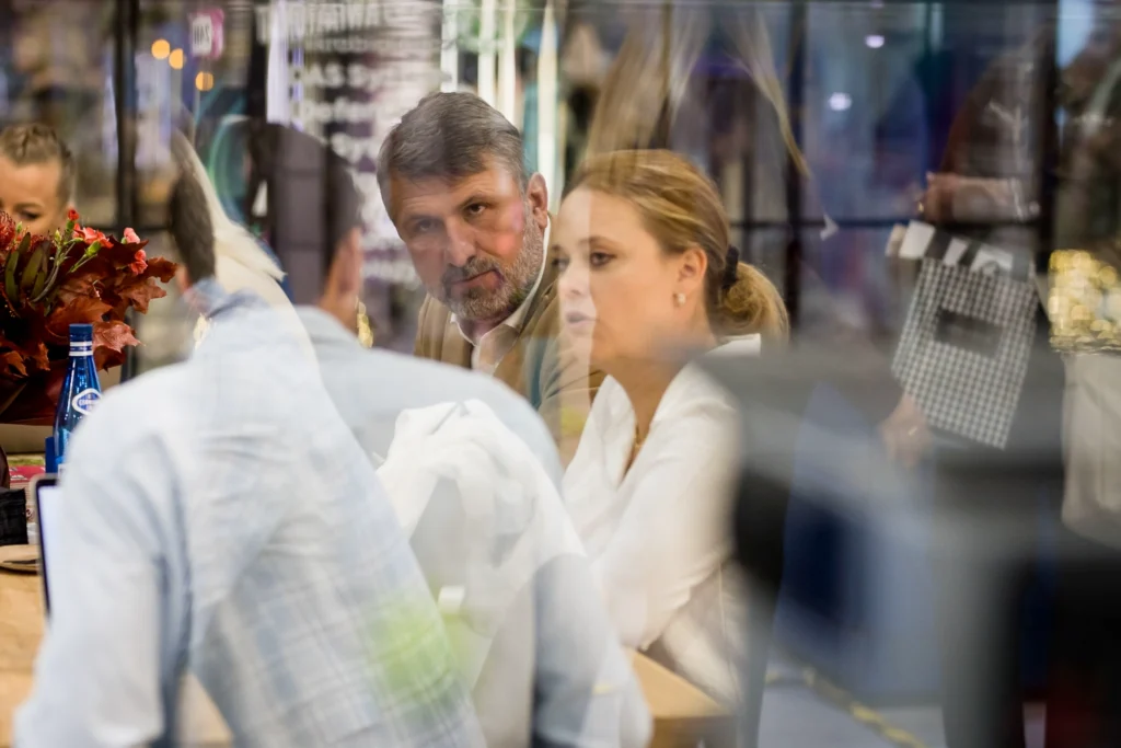 Partnerzy franczyzowi VendiFlor podczas rozmów na spotkaniu biznesowym, symbolizujących współpracę, dzielenie się doświadczeniem i długoterminowe partnerstwo w branży kwiatowej.