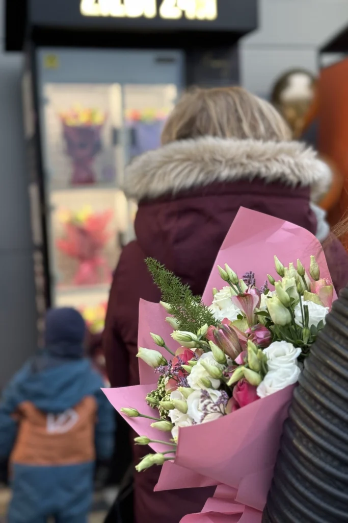 customer choosing bouquet from flower vending machine 24/7 Flowey Riga