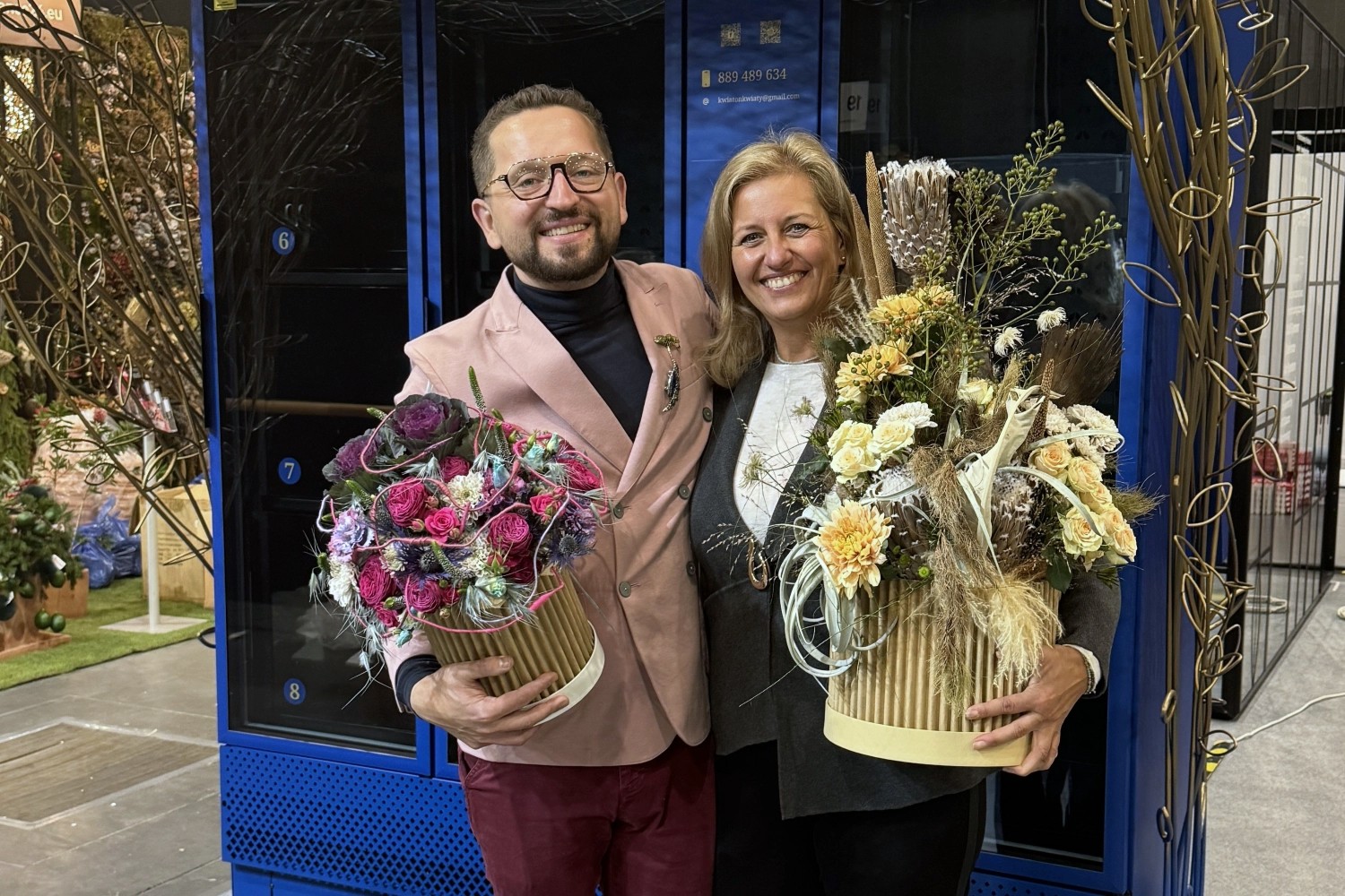 Florysta i florystka prezentują bukiety przygotowane do sprzedaży w Kwiatomacie