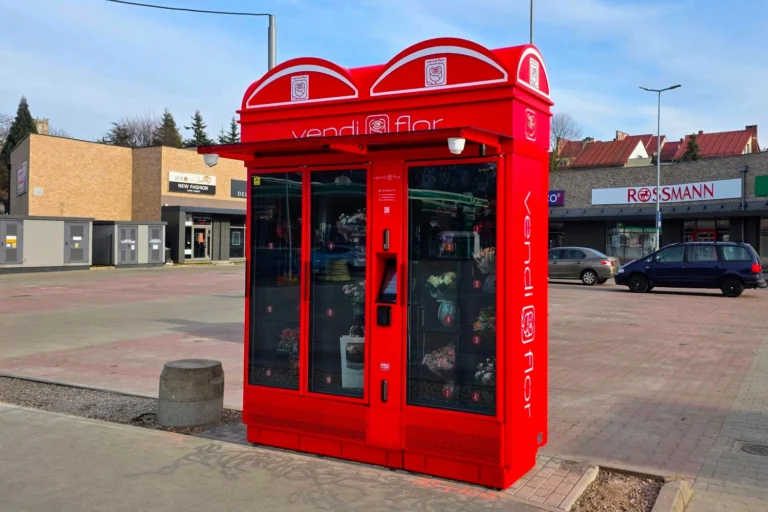 Czerwony Kwiatomat VendiFlor z podświetlanymi kasetonami reklamowymi i oznakowaniem bocznym, prezentujący możliwości personalizacji nowoczesnych automatów do sprzedaży kwiatów.